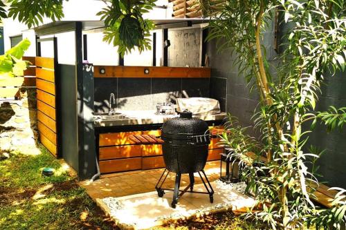a kitchen with a sink and a grill at Villa Rosa Palma 10 personnes piscine chauffée à St Gilles les bains in Saint-Paul