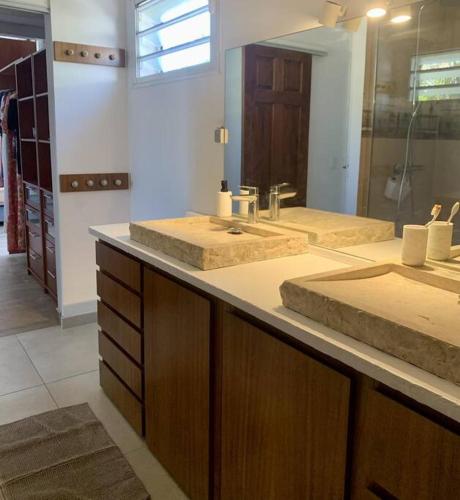 a bathroom with two sinks and a large mirror at Villa Rosa Palma 10 personnes piscine chauffée à St Gilles les bains in Saint-Paul