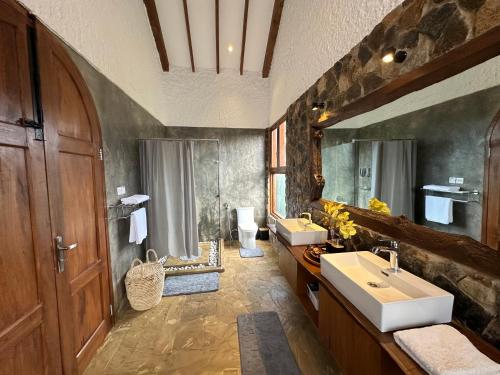 uma grande casa de banho com 2 lavatórios e um espelho grande em Tulivu Kilimanjaro Retreat em Msaranga