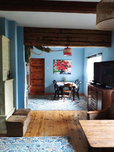a dining room with blue walls and a table with chairs at Trzemcha in Tuchów