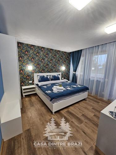 a bedroom with a large bed in a room at Casa Dintre Brazi in Nemţişor