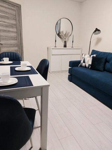 a living room with a blue couch and a table at Свежая 2-комнатная квартира в центре in Khmelʼnytsʼkyy