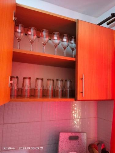 a row of wine glasses on a shelf in a kitchen at Christie's apartments Buruburu in Nairobi