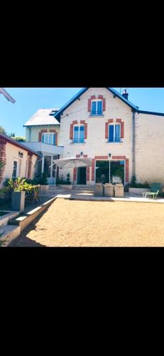 une grande maison blanche avec des fenêtres bleues et une allée. dans l'établissement Belle demeure de 1820, classée, à 5 mn de Blois, 10 mn de Chambord, à Vineuil