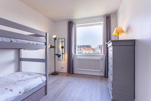 une chambre avec un lit superposé et une fenêtre dans l'établissement Le Carrousel - Appartement avec studio attenant, à Deauville