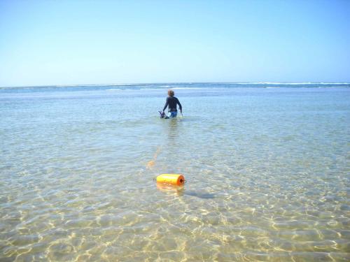 a man standing in the water with a yellow object at Naara Eco Lodge & Spa in Chidenguele