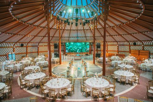 a banquet hall with white tables and chairs at Glory Resort Mongolia in Nalayh