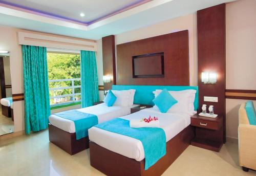 Habitación de hotel con 2 camas y ventana en HOTEL SRIVATSA REGENCY, en Pudunagaram