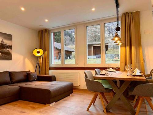 - un salon avec un canapé et une table dans l'établissement Mountain View Apartment, à Kandersteg