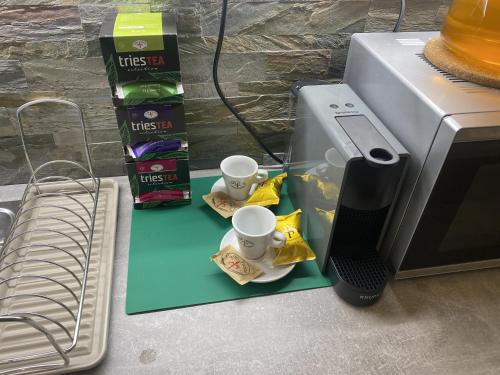 a table with two cups and a microwave at Apartmány Vodohospodár in Mýto pod Ďumbierom