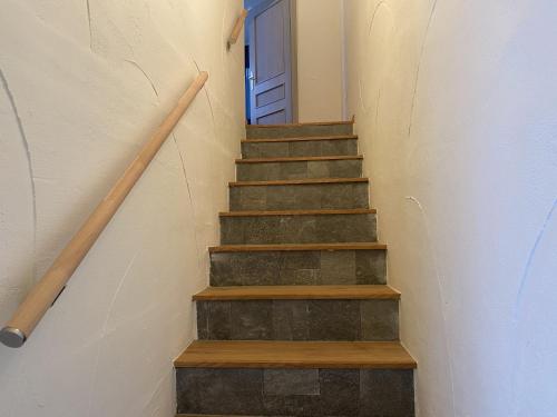 a stairway with a blue door and wooden stairs at Apartmány Vodohospodár in Mýto pod Ďumbierom