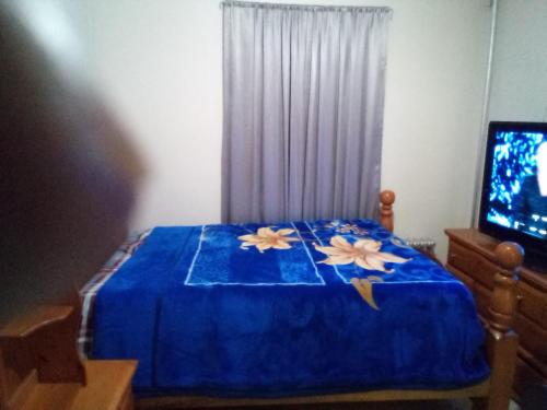 a bedroom with a blue bed with flowers on it at Hunts Point Short Stays in Hunts Point