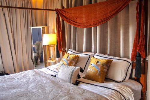 una camera da letto con letto, lenzuola e cuscini bianchi di Sunset ocean view hilltop house a Salad Beach