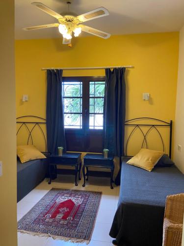 sypialnia z 2 łóżkami i wentylatorem sufitowym w obiekcie La Mar Poolvilla w Costa Teguise