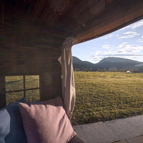 a view of a field from the inside of a barn at activechalets six.nine.eight in Reit im Winkl