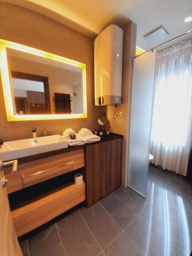 a bathroom with a sink and a mirror at Woodside RENT Kopaonik in Kopaonik