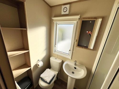 La petite salle de bains est pourvue de toilettes et d'un lavabo. dans l'établissement 2 Bedroom Caravan CW111, Whitecliff Bay, Bembridge, Isle of Wight, à Bembridge