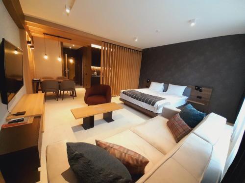 a hotel room with a bed and a couch at Woodside RENT Kopaonik in Kopaonik