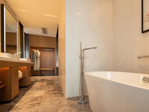 a bathroom with a large tub and a sink at Hampton by Hilton Chengdu Xibo City in Chengdu