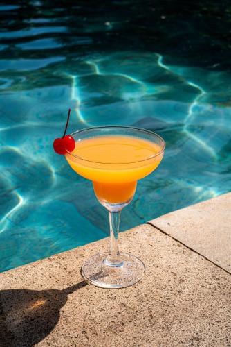 a drink in a glass next to a swimming pool at Novotel Bali Nusa Dua in Nusa Dua