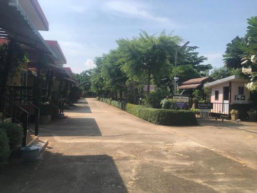 an empty street in a town with houses and trees at วังอินธารา รีสอร์ท (Wangintara Resort) in Phitsanulok