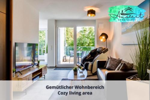 sala de estar con sofá y TV en Auszeit Apartment HARMONY am Uferpark - nur 100 m bis zum Bodensee, direkt am Bodenseeradweg, Seeblick, Sonnenbalkon, Massagesessel, schnelles WLAN, kostenloser Parkplatz, für bis zu 2 Personen, en Friedrichshafen
