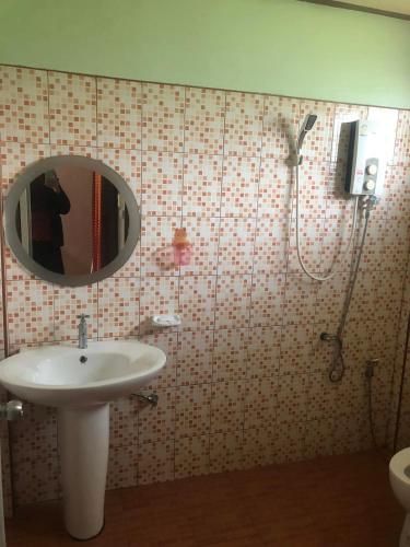 a bathroom with a sink and a shower with a mirror at วังอินธารา รีสอร์ท (Wangintara Resort) in Phitsanulok