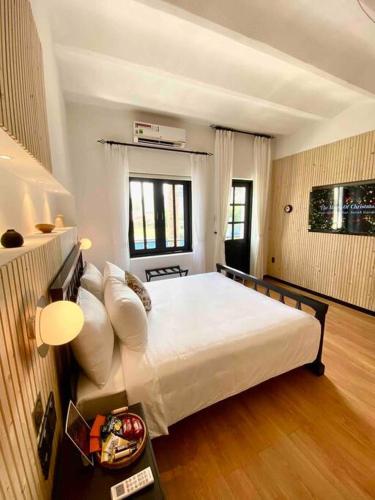 ein Schlafzimmer mit einem großen weißen Bett in einem Zimmer in der Unterkunft Daniel's Studio in Saigon Center with Hot tub and View in Ho-Chi-Minh-Stadt