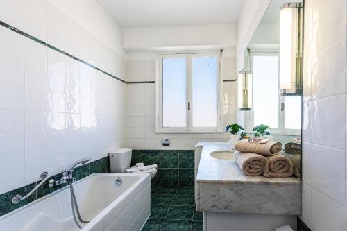 une salle de bain blanche avec une baignoire et un lavabo dans l'établissement PLAZA TERRACE AP4065 by RIVIERA HOLIDAY HOMES, à Nice