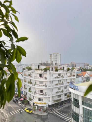 a large white building with a parking lot at Đông Xuyên Hotel in Long Xuyên