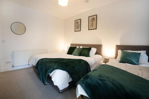 a bedroom with two beds with green and white sheets at Near hospital, Netflix, Sleeps up to 3, Fast Wi-FI in Lincolnshire