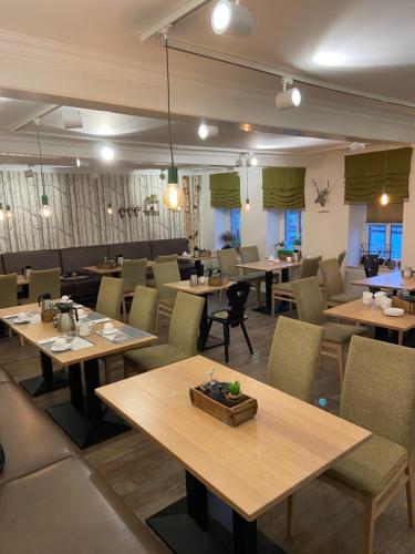 a restaurant with tables and chairs in a room at Hotel Zum Großen Krug in Wirdum
