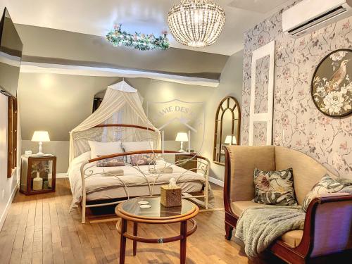 une chambre avec un lit, un canapé et une table dans l'établissement La Romantique des Rois # Jacuzzi # Sauna, à Dourdan