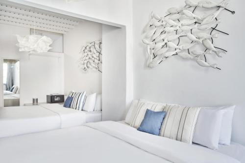 two beds in a room with white walls at Whitelist Suite Fabrika in Mykonos Town in Mýkonos City