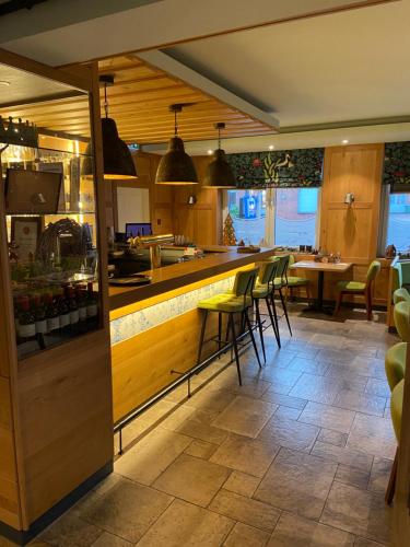 a restaurant with a bar with chairs and tables at Hotel Zum Großen Krug in Wirdum