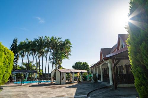a resort with a swimming pool and palm trees at Villa charmante à Saint-Benoît avec piscine privée in Saint-Benoît