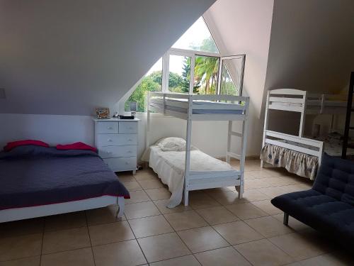 a bedroom with two bunk beds and a window at Villa charmante à Saint-Benoît avec piscine privée in Saint-Benoît