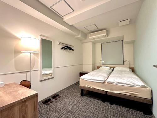 1 dormitorio con cama y escritorio. en Room&Bed Fun stay KYOTO en Kyoto