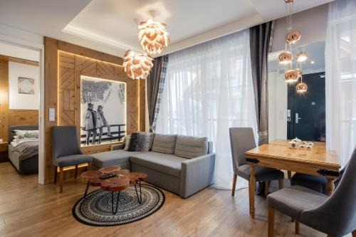 - un salon avec un canapé et une table dans l'établissement Apartament Góralska Nuta SPA Basen & Sauna, à Zakopane