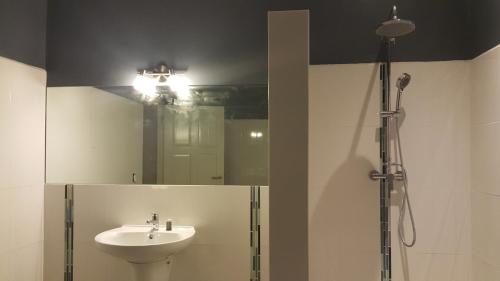 two pictures of a bathroom with a sink and a shower at Guesthouse Curacao in Willemstad