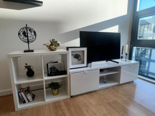 a white entertainment center with a flat screen tv at Luxury Modern Canary 1 bedroom Apartment in London