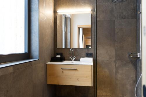 W łazience znajduje się umywalka i lustro. w obiekcie Heimat 1495m Appartement TYP 4 w mieście Schröcken
