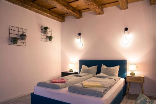een slaapkamer met een bed met twee lampen aan de muur bij Seek and Hide - Csilla's Tiny Hideaway in Braşov
