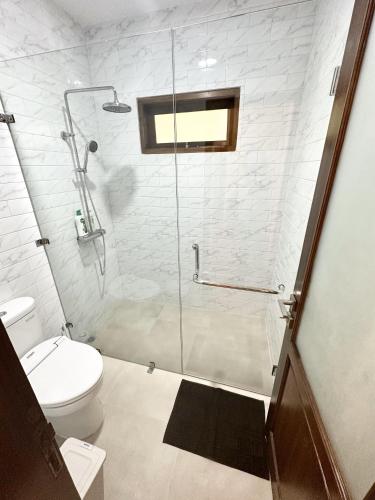 a bathroom with a glass shower with a toilet at Villa Putih Le Cordon in Bandung