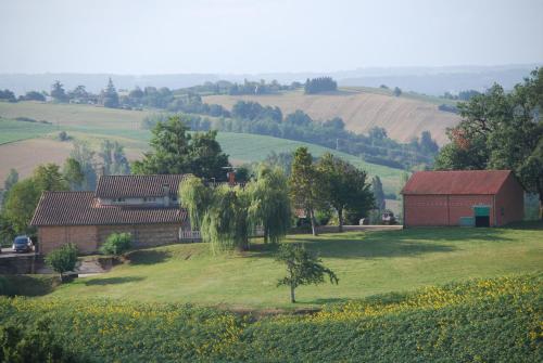 una granja con un granero y un campo de hierba en Les Goullans, en Grazac