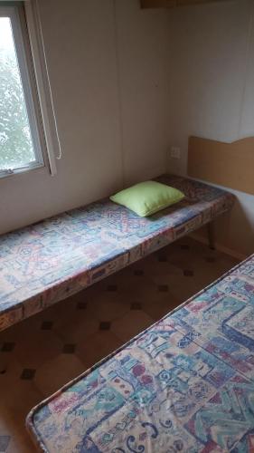 two beds sitting in a room with a window at Camping le pré fleuri 