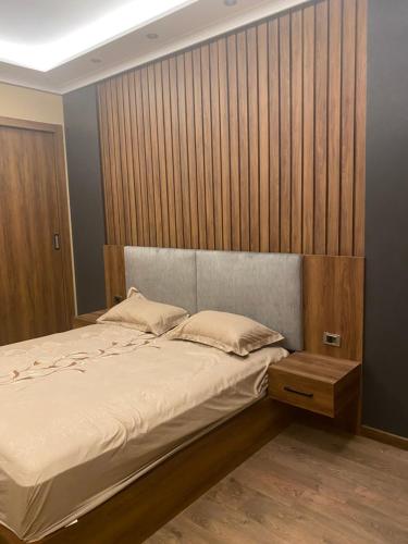 a bedroom with a large bed and a wooden wall at black tiger villa in ‘Ezbet `Abd el-Ḥamîd