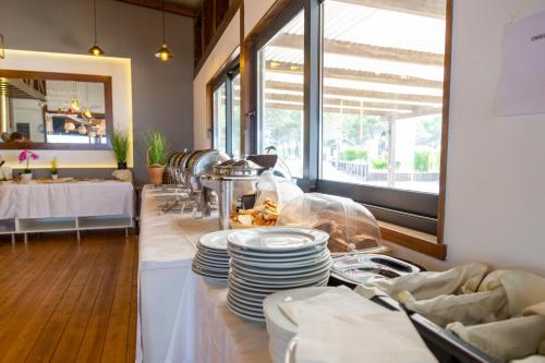 a restaurant with a table with plates on a counter at MCM Camping in Ulcinj
