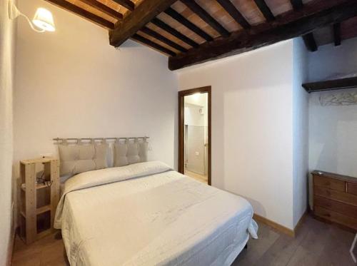 a bedroom with a white bed and a wooden ceiling at Casa Tòrta - Tuscan ToBe in Santa Fiora