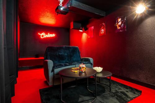 Habitación roja con silla y mesa en Cocon Relax - Cinéma - Les Cocons de Nath, en Montbéliard
